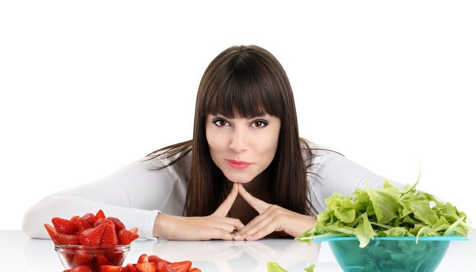 kobieta przy stole z ziołami i truskawkami